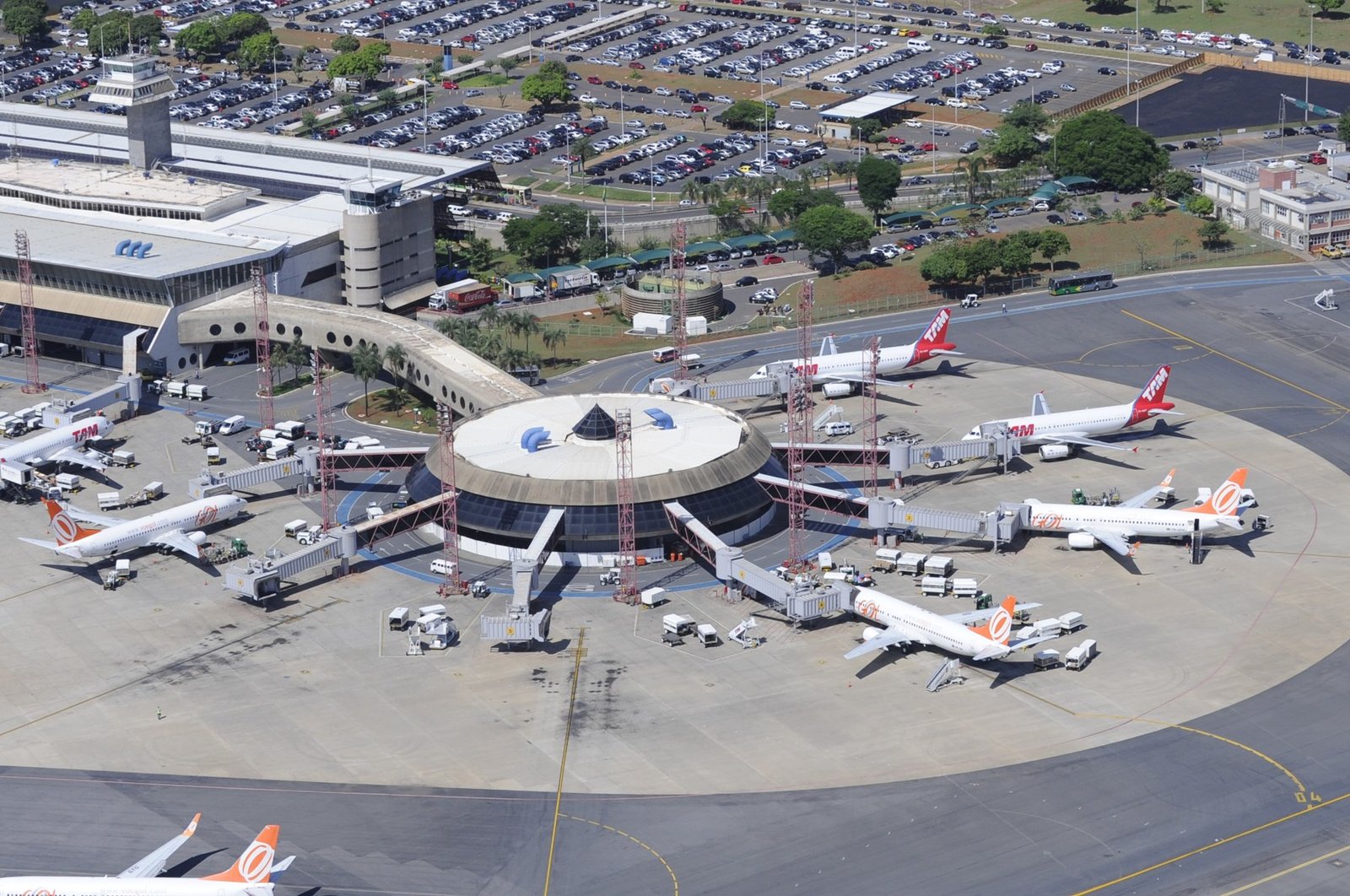 Vista aérea do terminal do Aeroporto Internacional de Brasília, com aviões nos portões e o estacionamento ao fundo (foto de arquivo de 2012)