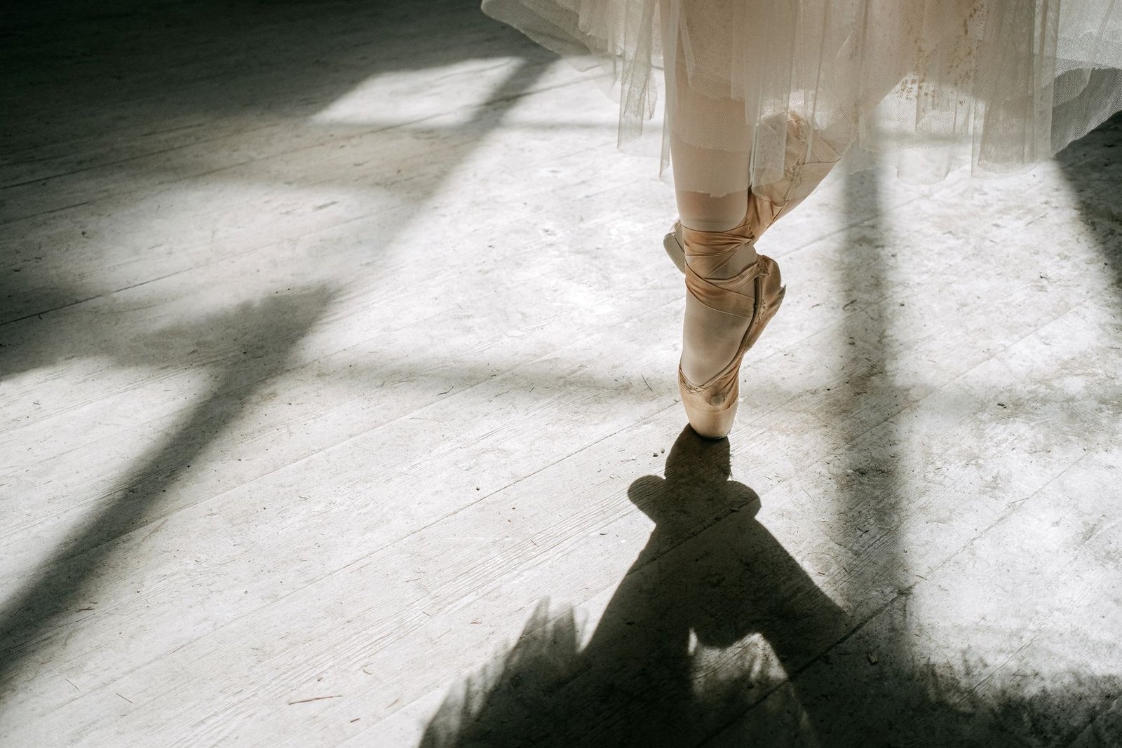 Sapatilha de ponta de uma bailarina em sala de ensaio com luz entrando pela janela