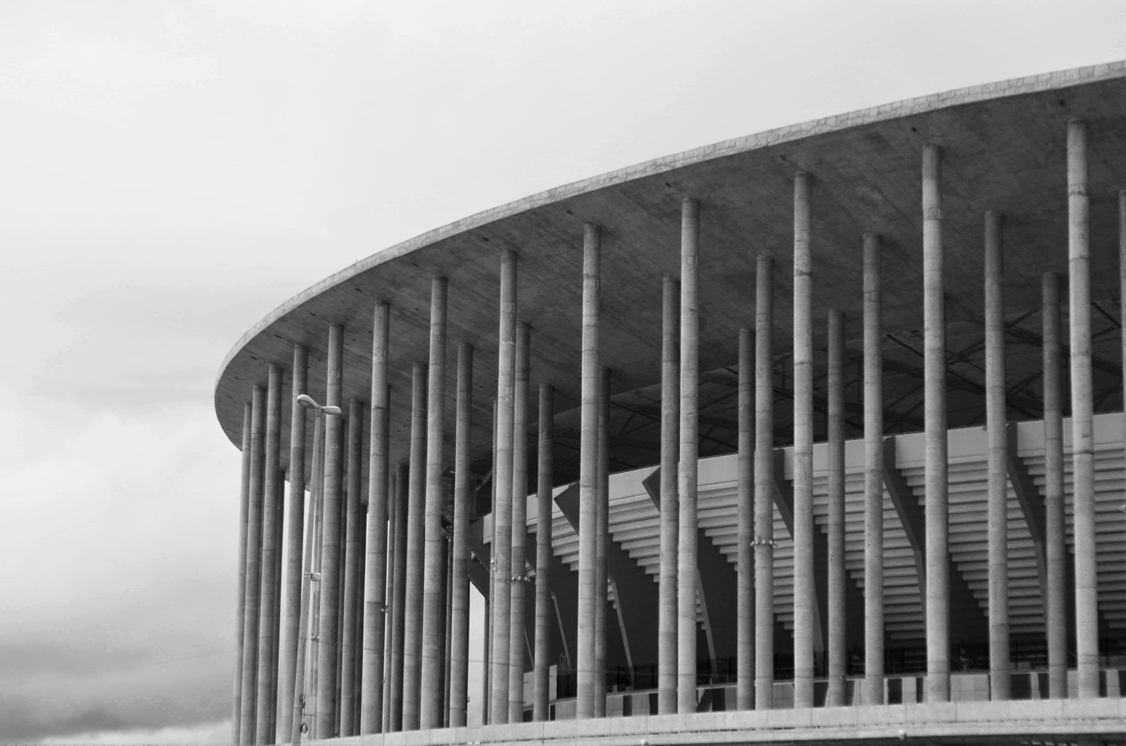Colunas de concreto e cobertura da Arena Mané Garrincha, em preto e branco