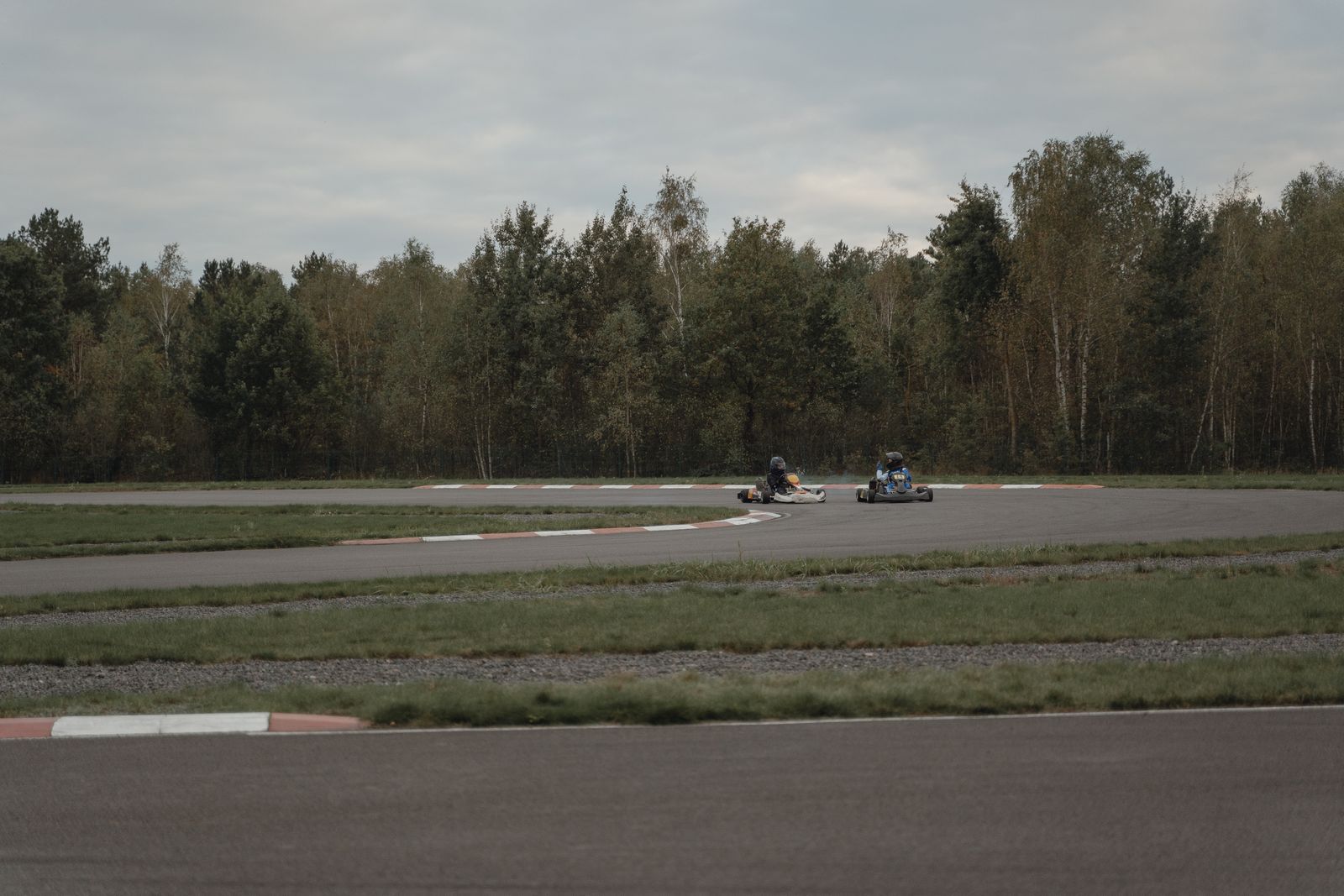 Dois karts de competição disputam curva em pista de kartódromo