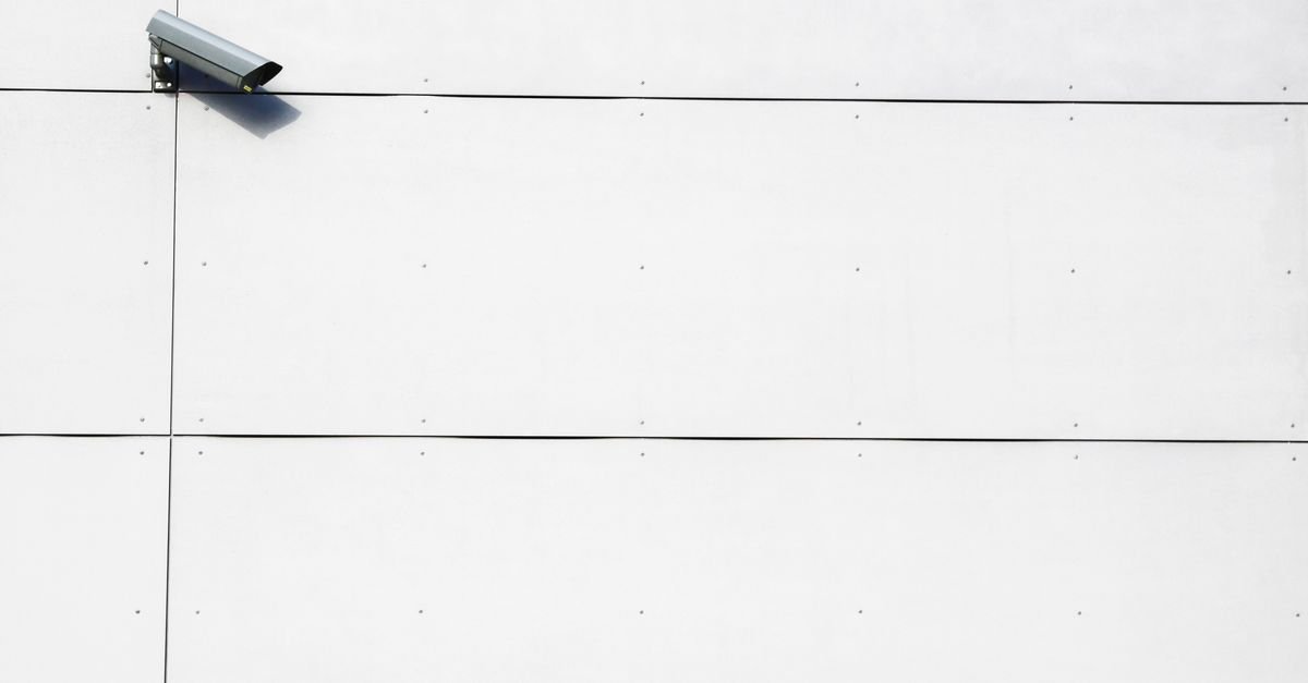 Câmera de segurança instalada em parede branca lisa