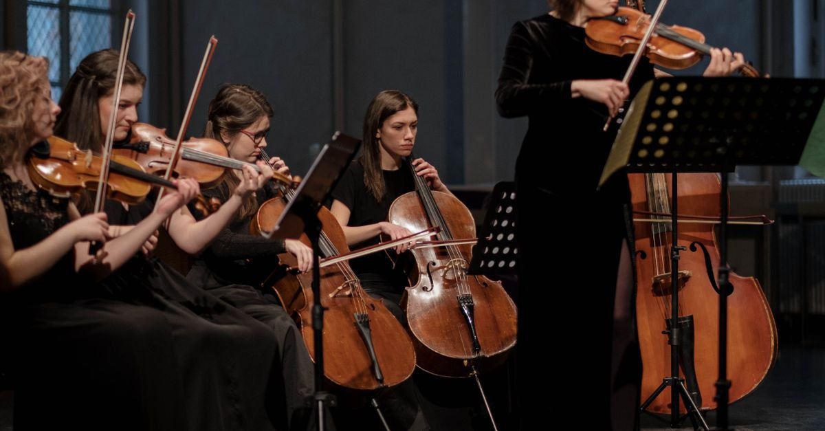 Quarteto de cordas com violinos e violoncelos em apresentação ao vivo com iluminação baixa