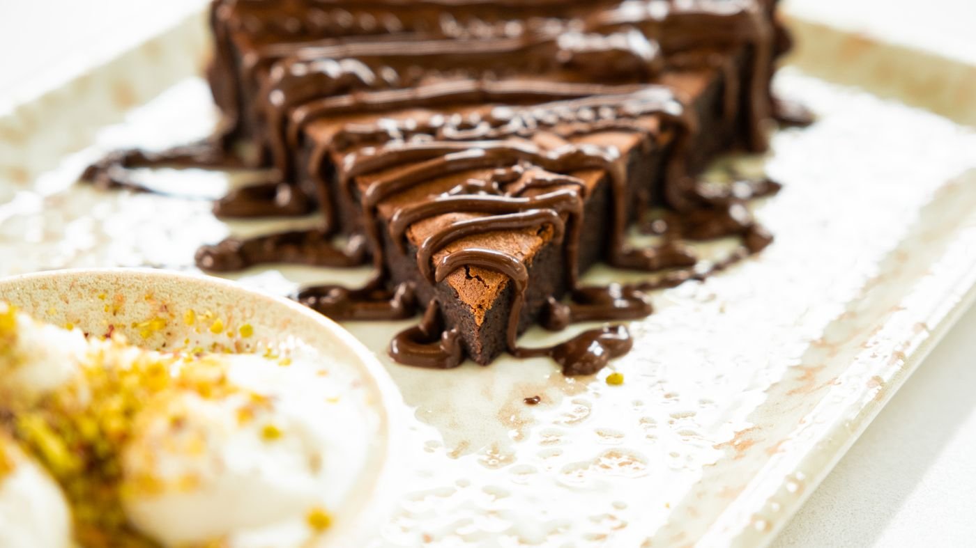 Fatias de brownie de chocolate com calda em prato retangular