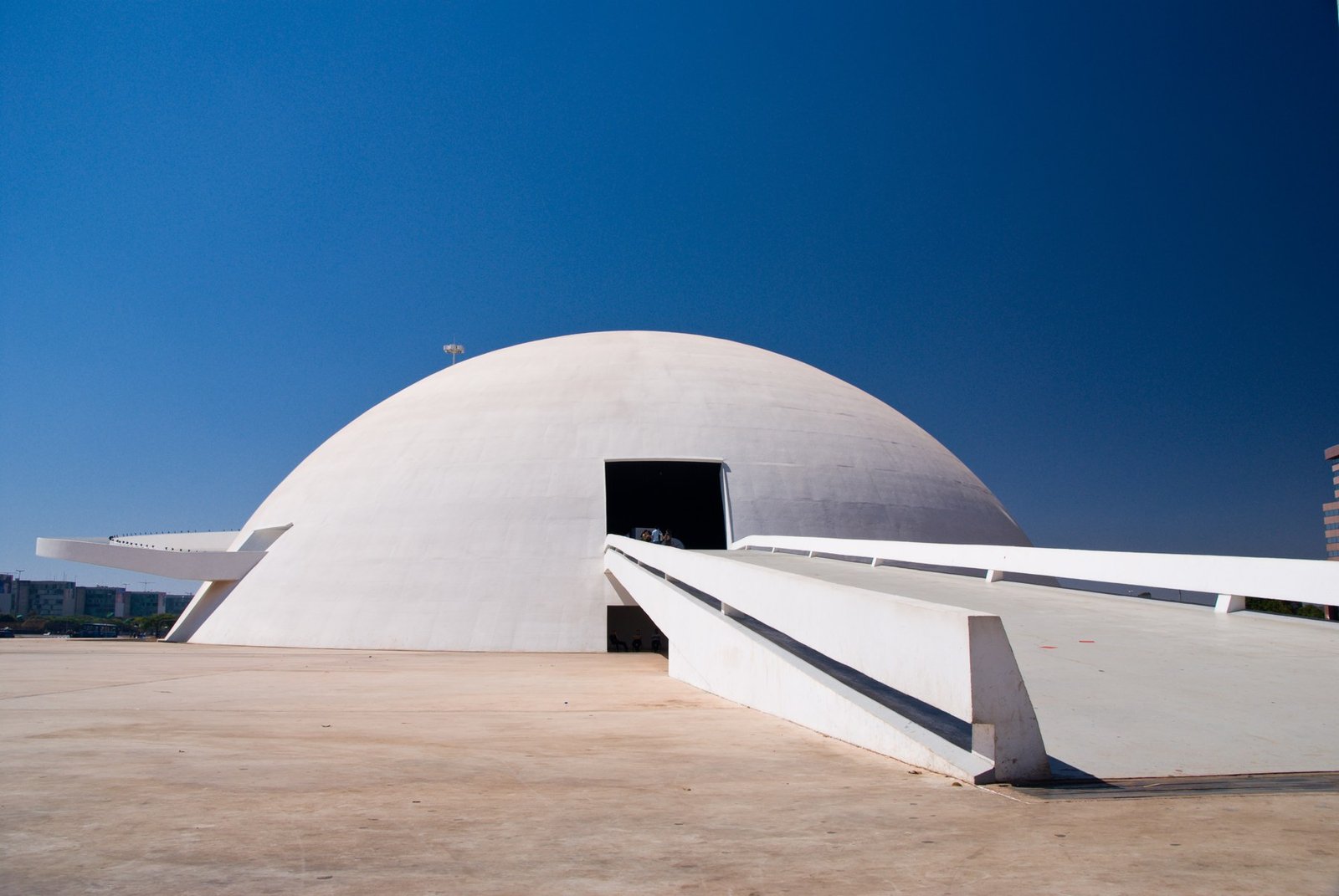 Cúpula branca do Museu Nacional da República em Brasília, com céu azul e rampa de acesso
