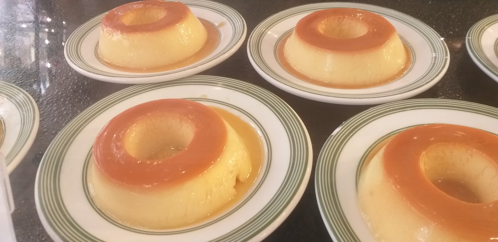 Pudins de leite condensado com calda de caramelo servidos em pratos individuais (foto ilustrativa de arquivo)