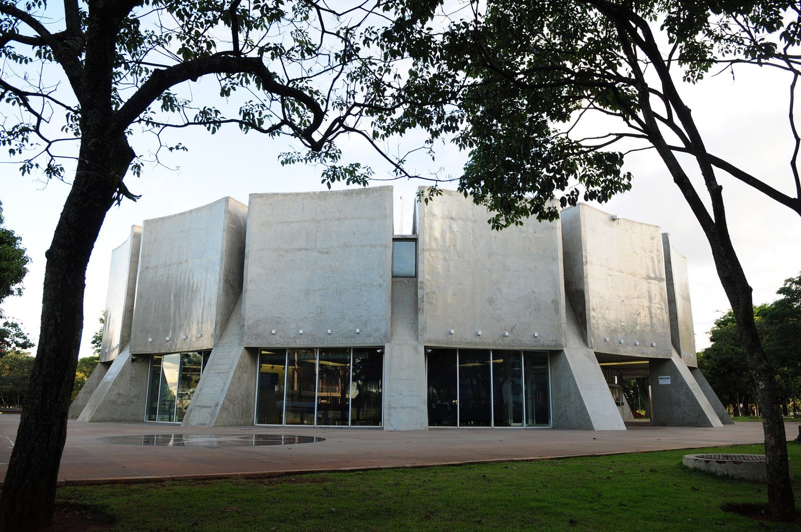 Planetário de Brasília, edifício de concreto aparente visto entre árvores
