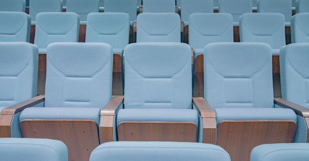 Fileiras de poltronas azuis vazias em um auditório
