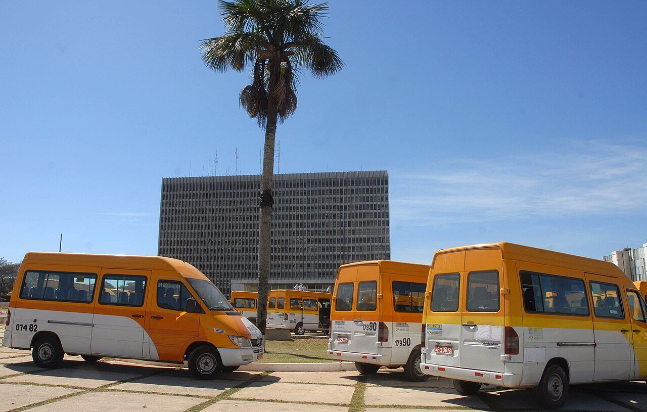 Veículos de transporte coletivo estacionados lado a lado em área aberta de Brasília