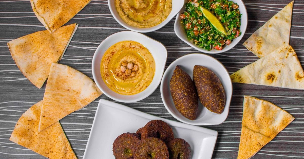 Mesa com homus, quibe, tabule e pão sírio, pratos típicos da cozinha árabe