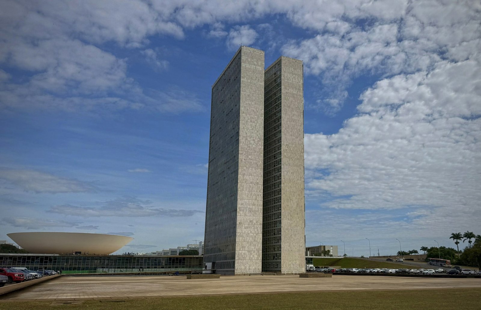 As duas torres do Congresso Nacional e a cúpula do Senado sob céu azul com nuvens