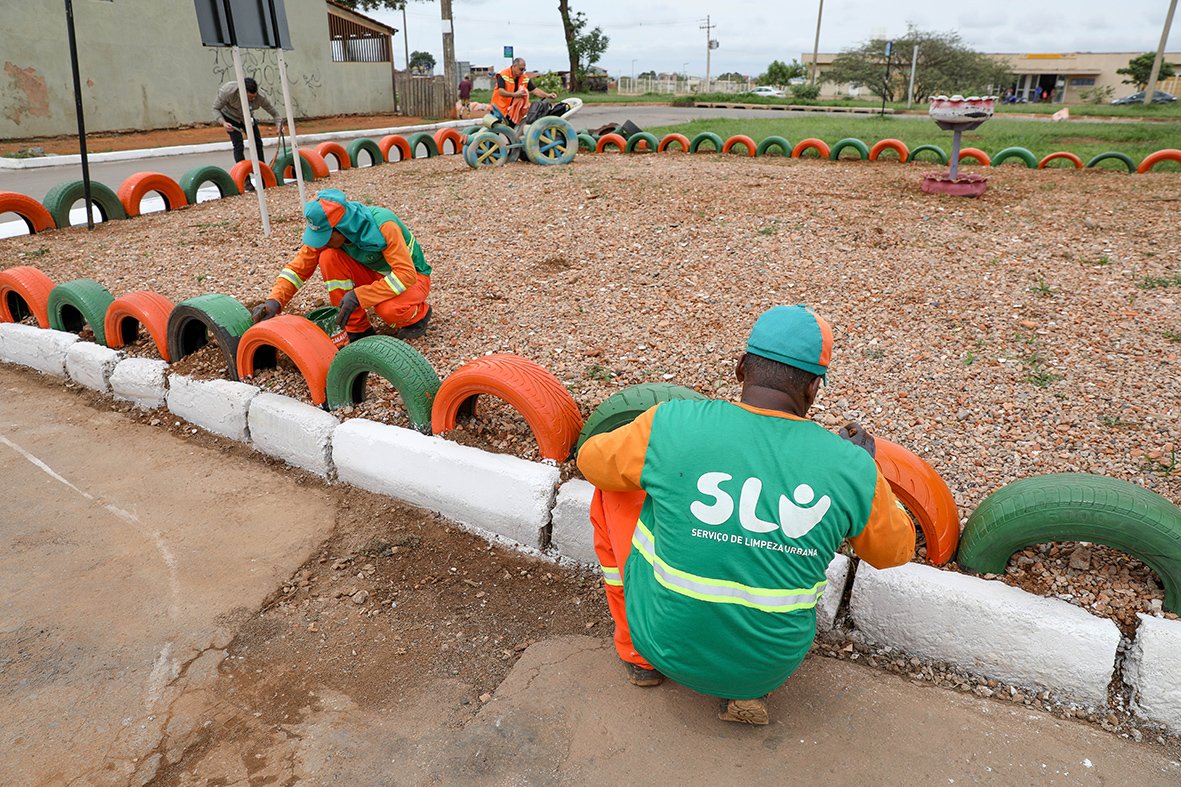 Equipe do SLU pinta pneus nas cores verde e laranja em área recuperada