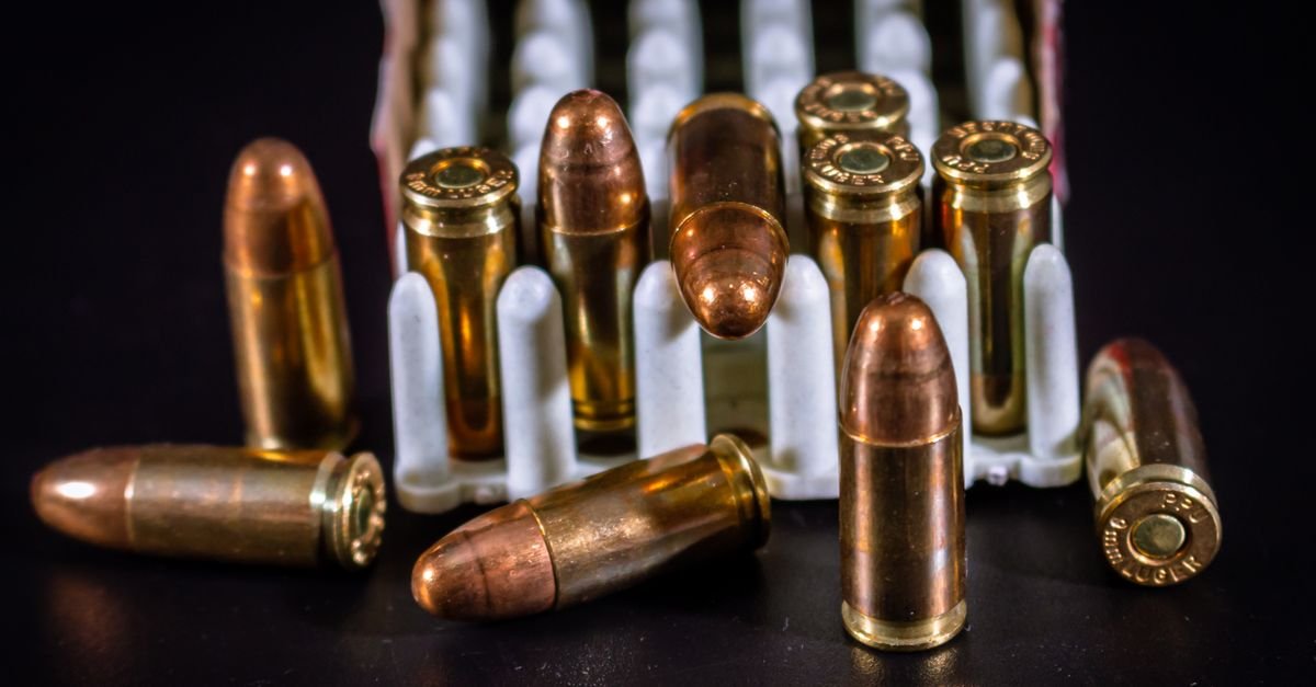 Munições de pistola calibre 9 mm em close sobre superfície escura