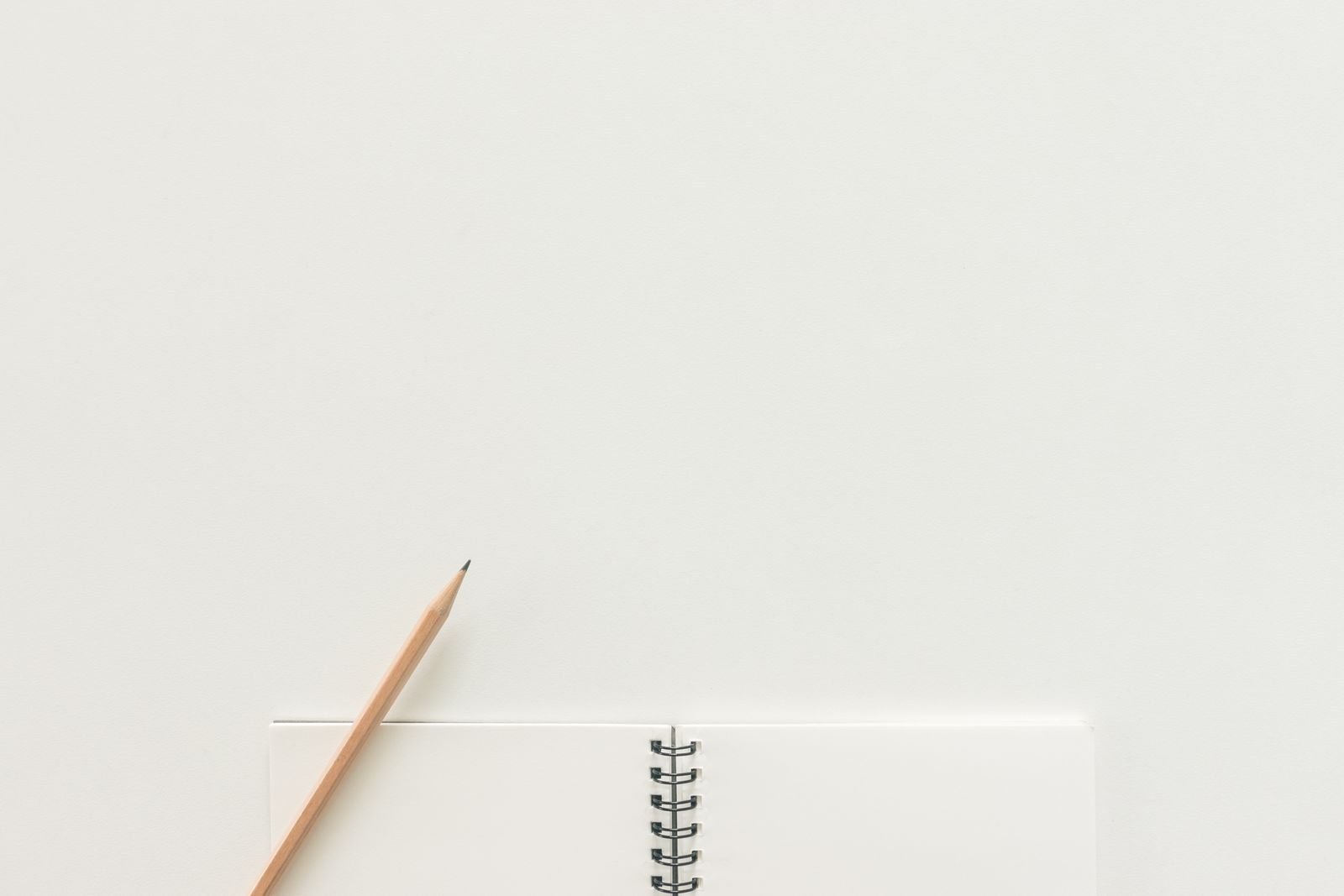 Caderno de espiral com um lápis sobre superfície clara