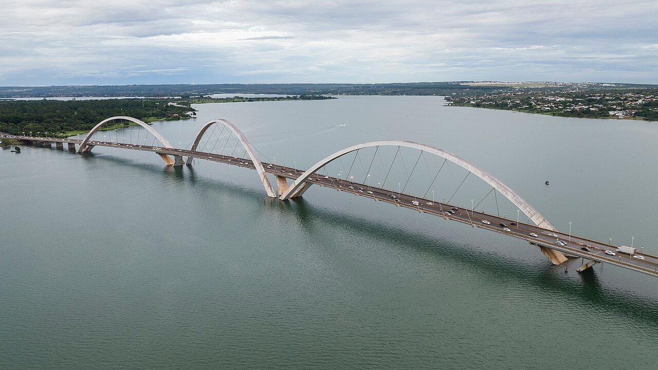 Vista aérea da Ponte JK sobre o Lago Paranoá, em Brasília, com os três arcos de aço