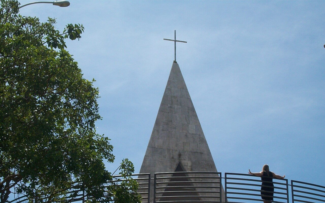 Visitante no mirante da Ermida Dom Bosco, com a capela em forma de pirâmide atrás