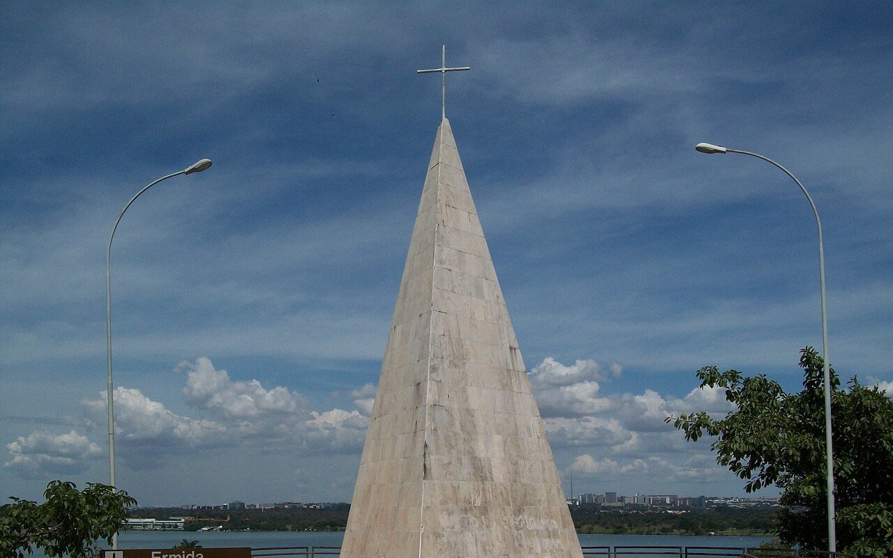 Pirâmide de pedra da Ermida Dom Bosco com cruz no topo e o Lago Paranoá ao fundo