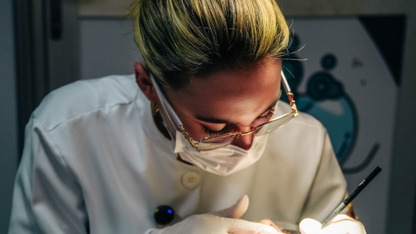 Dentista de óculos e jaleco sorri na unidade do Odonto em Ação