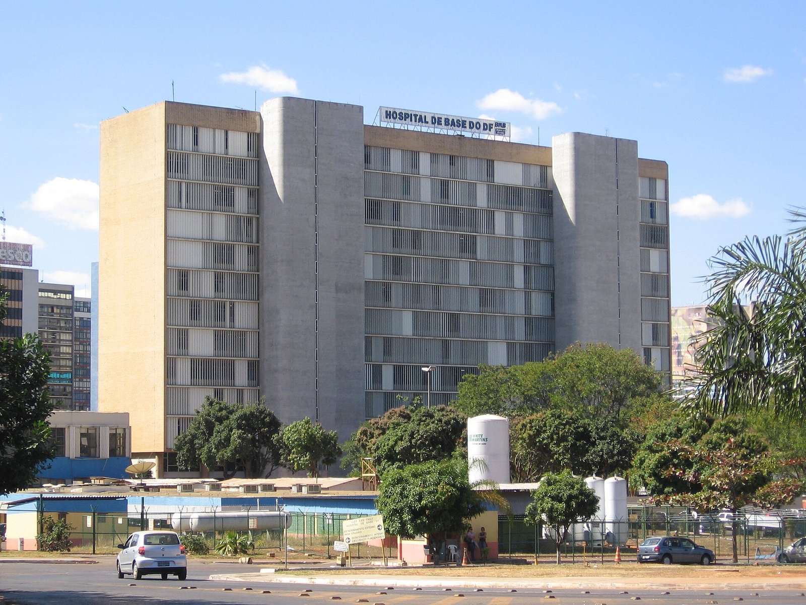Fachada do Hospital de Base do DF, prédio de dez andares com letreiro no alto, visto da via em frente