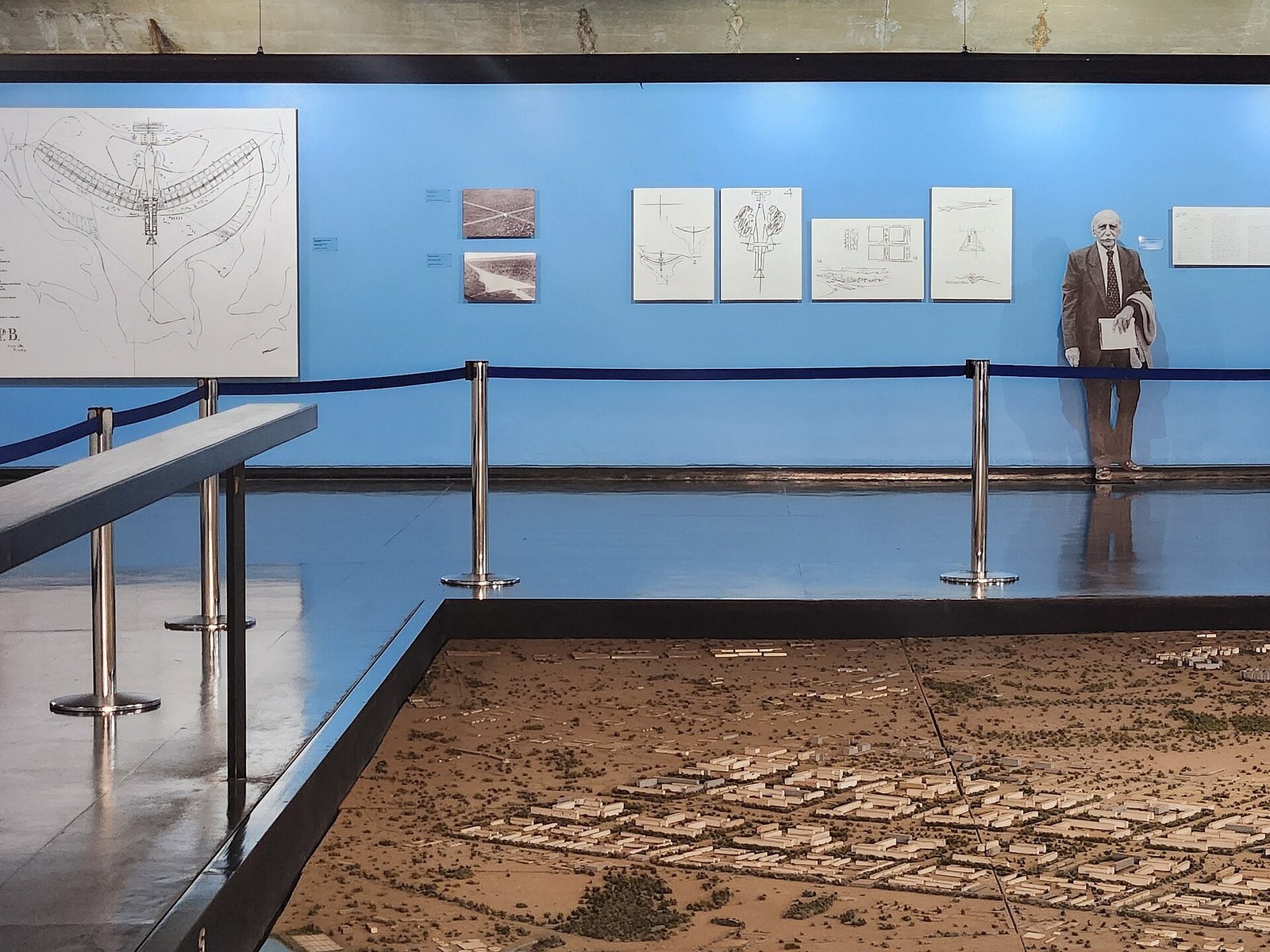 Sala azul do Espaço Lúcio Costa com croquis do Plano Piloto na parede e a maquete de Brasília em primeiro plano