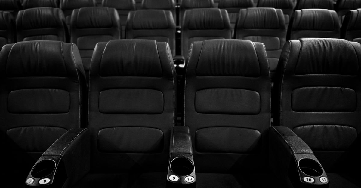 Fileiras de poltronas vazias em sala de cinema
