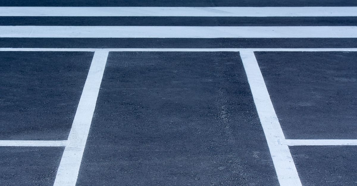 Marcações brancas de faixa de pedestres pintadas sobre asfalto