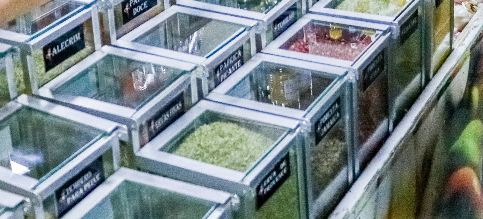 Caixas de vidro com temperos a granel em banca da Feira do Guará