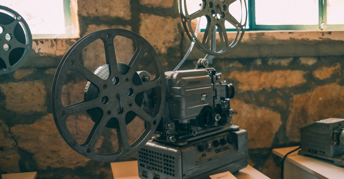 Projetor de cinema antigo com rolos de filme montados sobre bancada