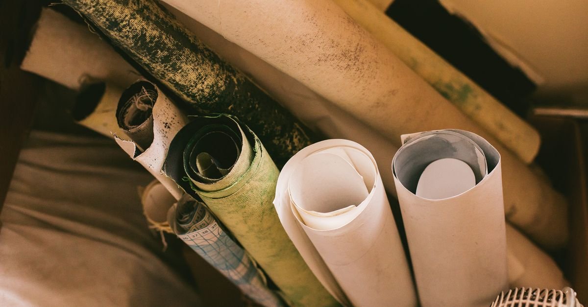 Rolos de papel de diferentes texturas e cores guardados juntos em uma caixa