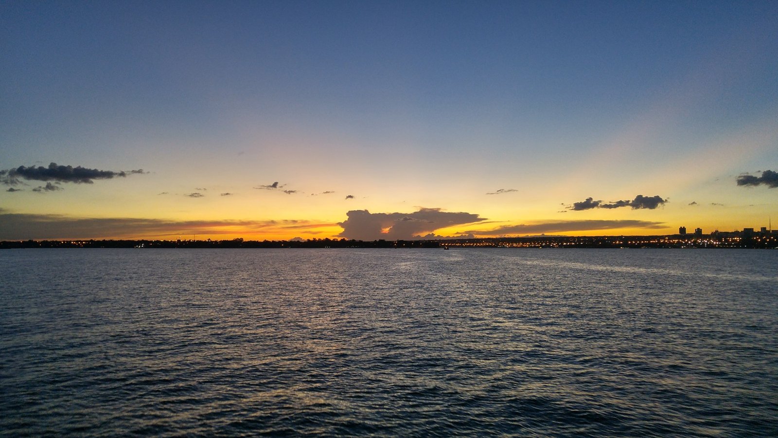 Pôr do sol sobre o Lago Paranoá, em Brasília, com a cidade ao fundo