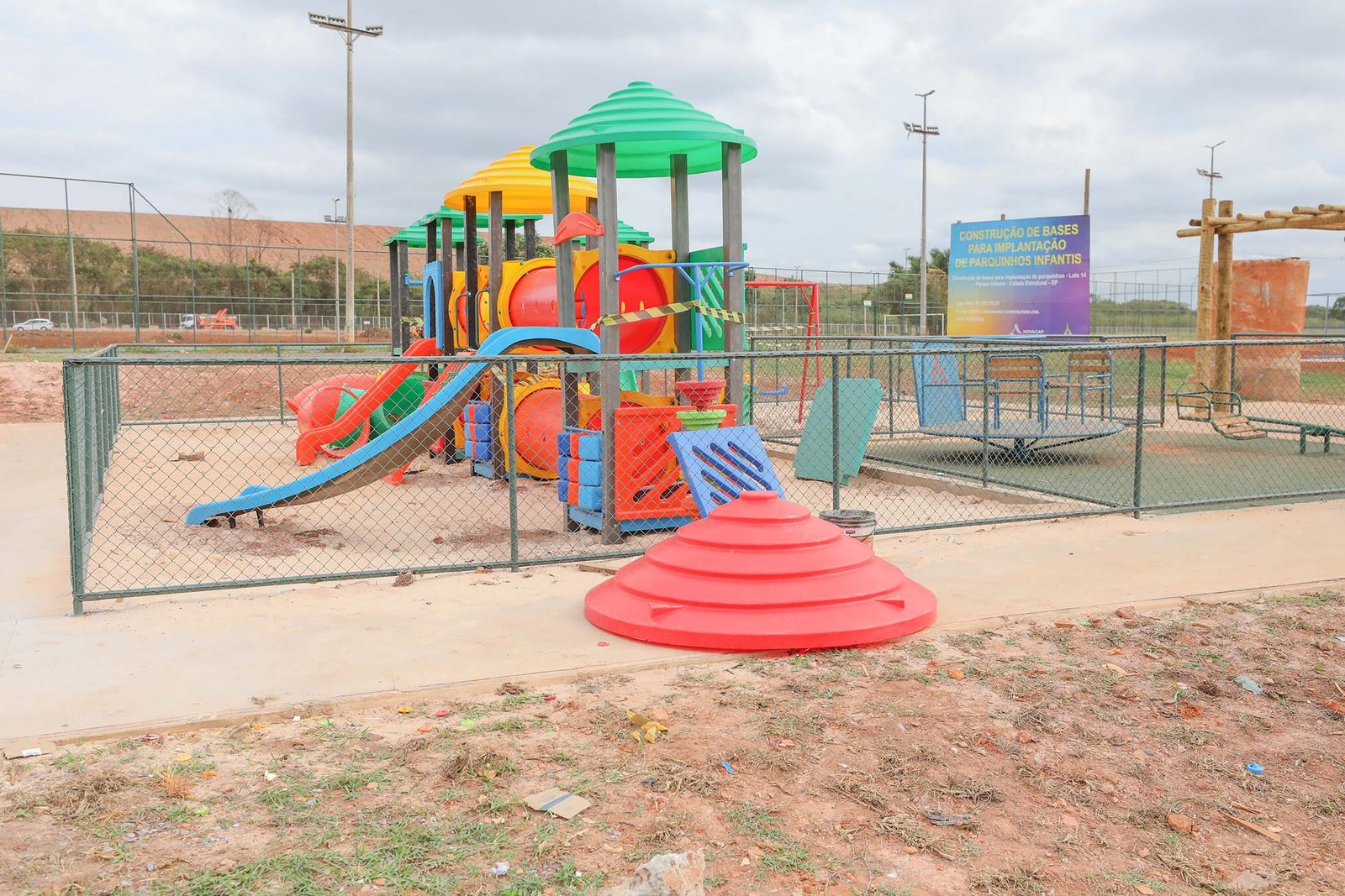 Parquinho infantil em obra no parque urbano da Estrutural, com placa da Novacap