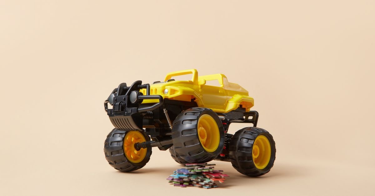 Miniatura de monster truck amarelo com pneus grandes sobre fundo claro