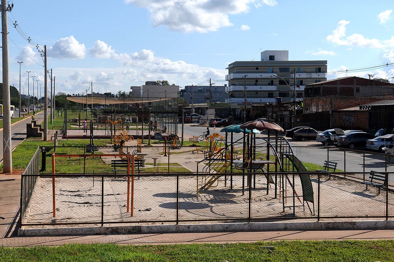 Praça com equipamentos de ginástica e comércio ao fundo em rua do Itapoã, no Distrito Federal