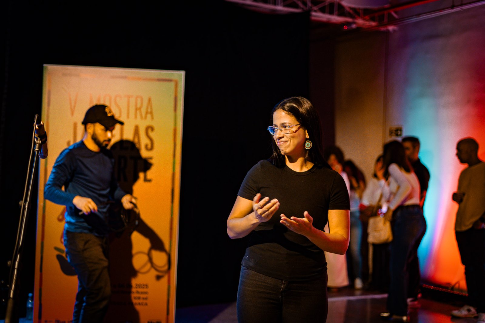 Intérprete faz Libras no palco durante evento do projeto Janelas da Inclusão
