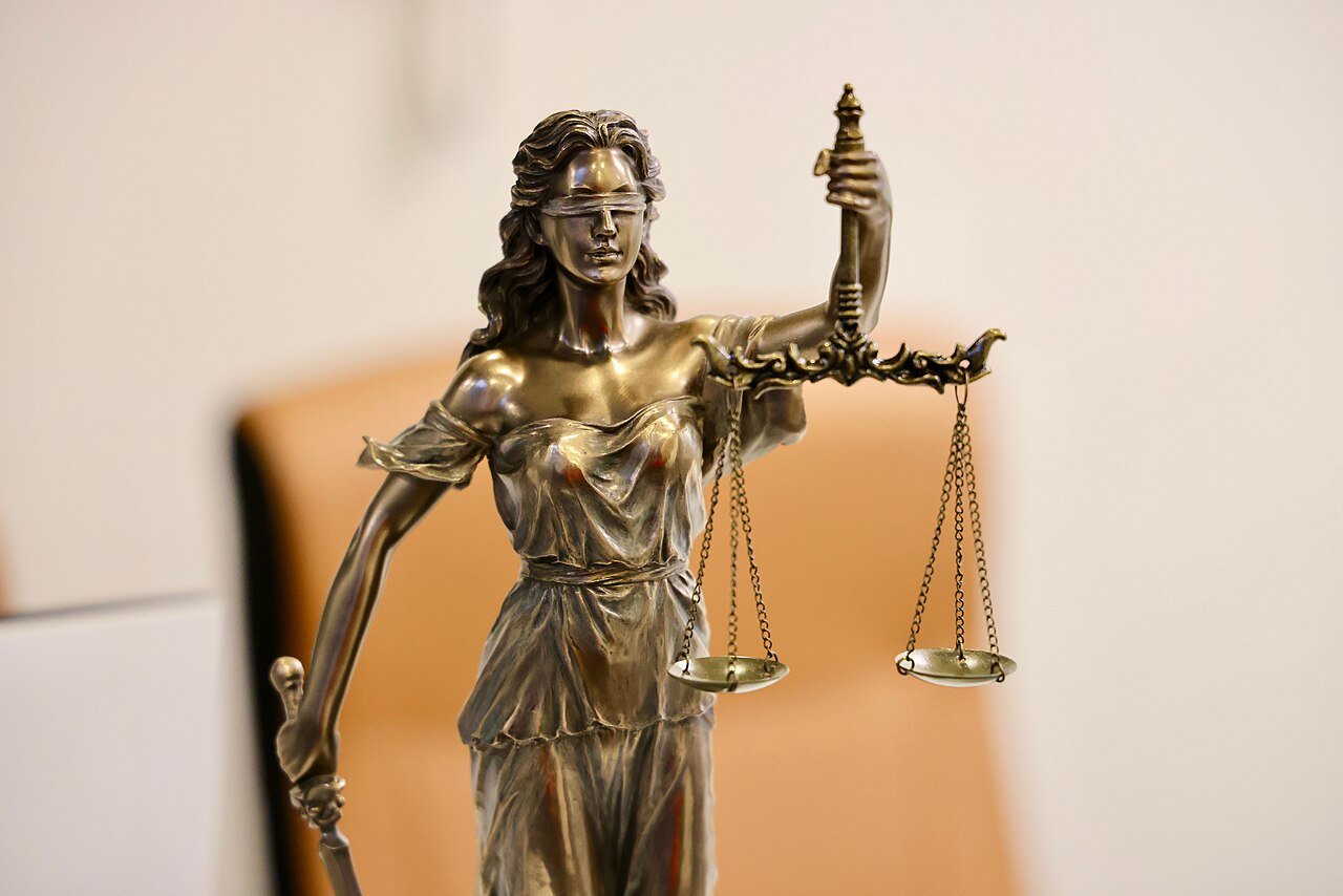 Estátua da Justiça com os olhos vendados segurando a balança, em imagem de ilustração