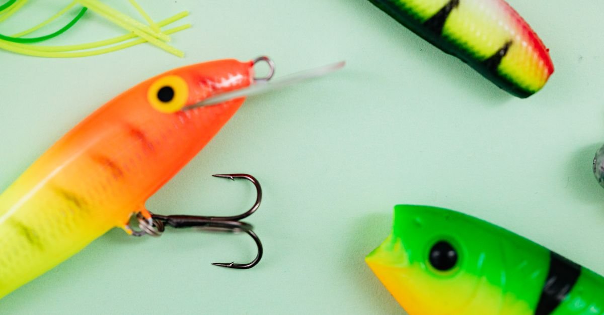 Iscas artificiais e anzóis de pesca sobre fundo claro