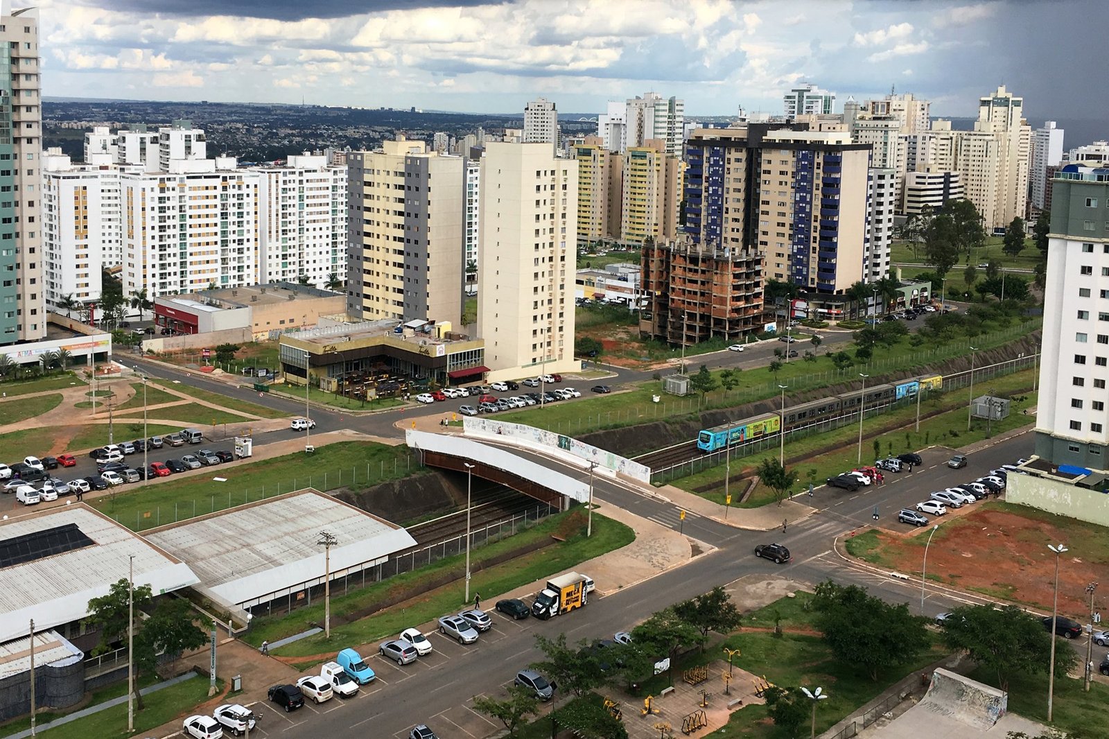 Trem do Metrô-DF passa em trecho aberto entre prédios de Águas Claras, visto do alto