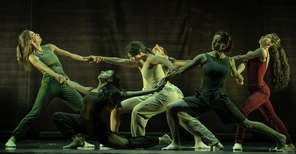 Grupo de bailarinos em movimento durante espetaculo de danca contemporanea