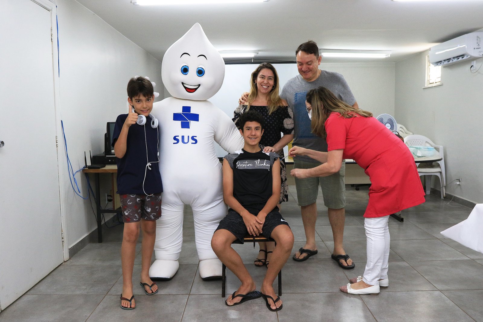 Adolescente recebe vacina em unidade de saúde do DF ao lado do boneco Zé Gotinha, do SUS