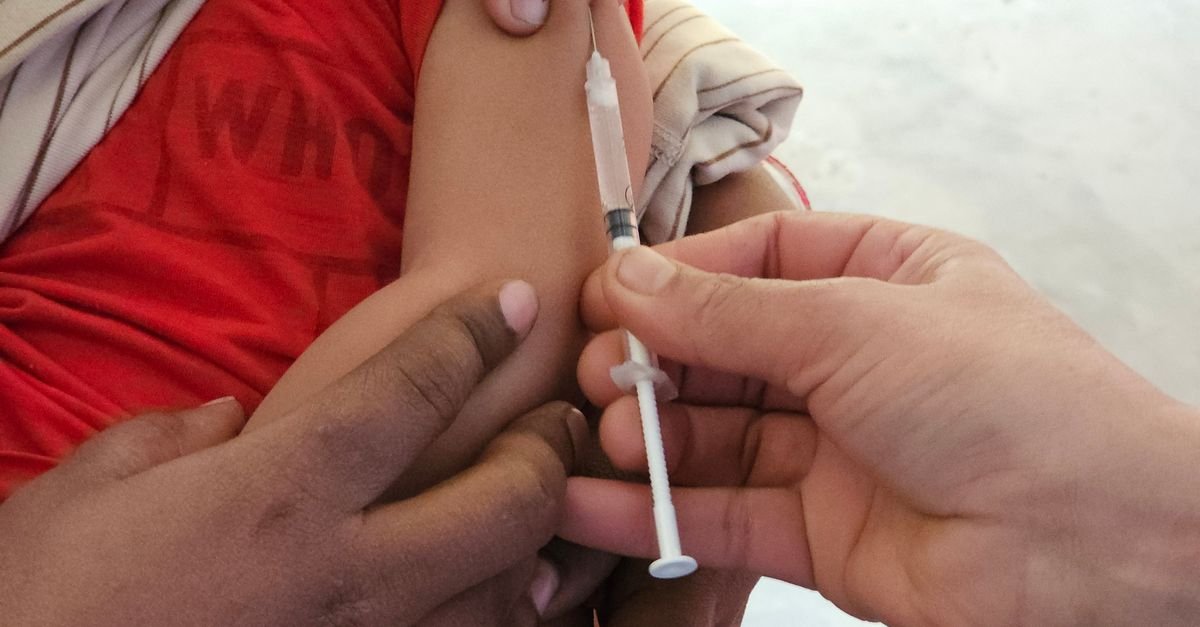 Profissional de saúde aplica vacina no braço de uma criança