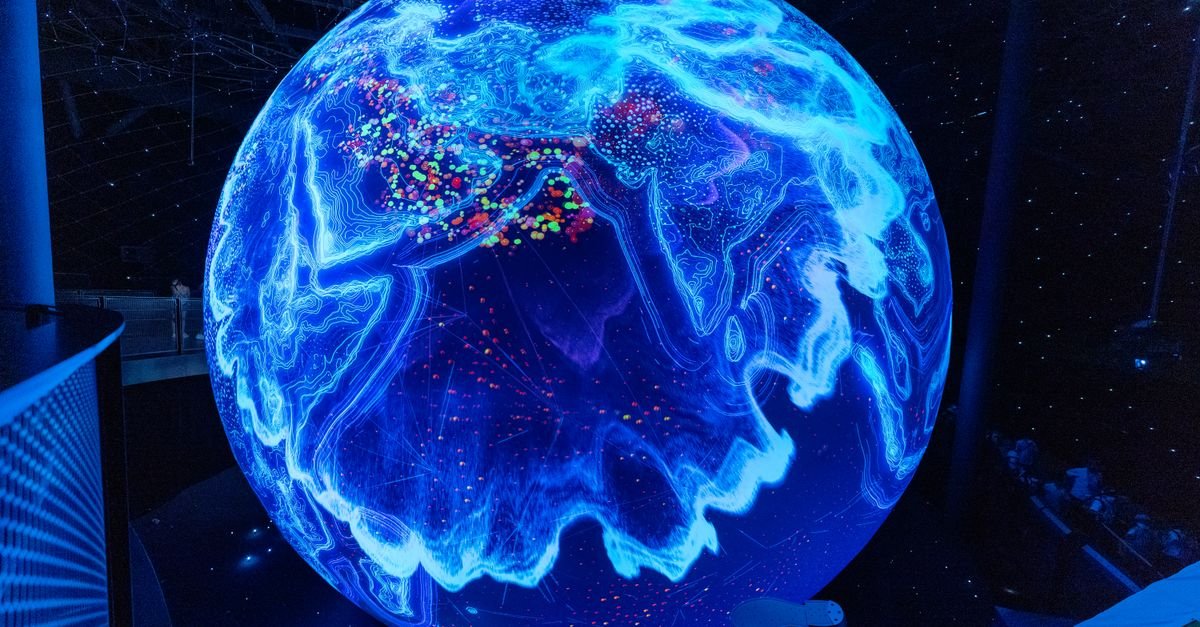 Globo luminoso azul de grande porte exibido em sala escura de museu de ciencia, imagem ilustrativa