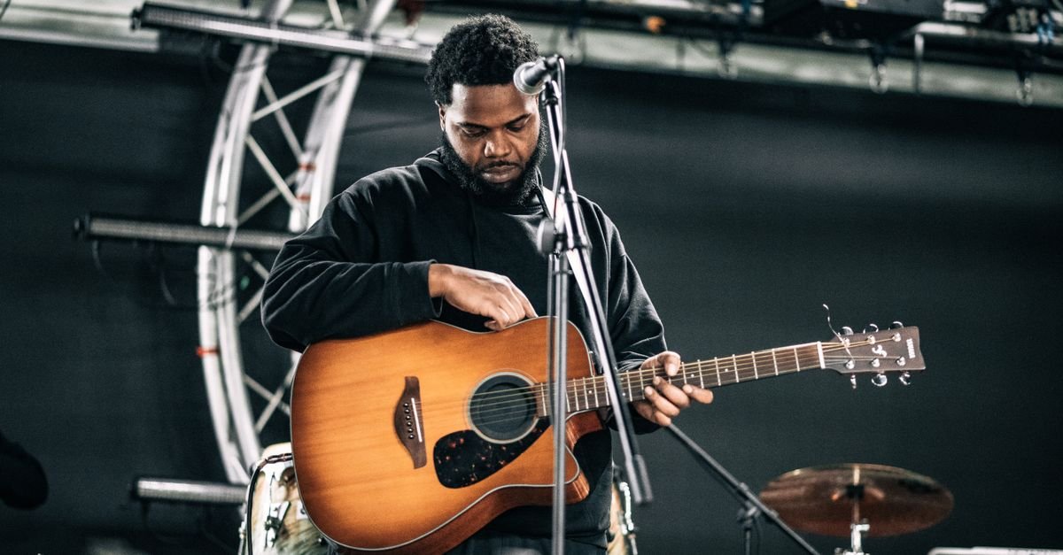 Músico afina o violão no palco antes de uma apresentação ao vivo, em imagem ilustrativa
