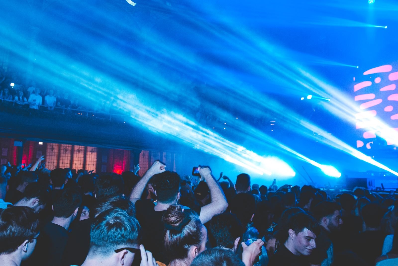 Plateia diante de feixes de laser azuis em show de música eletrônica (foto ilustrativa, não é do Lobby)