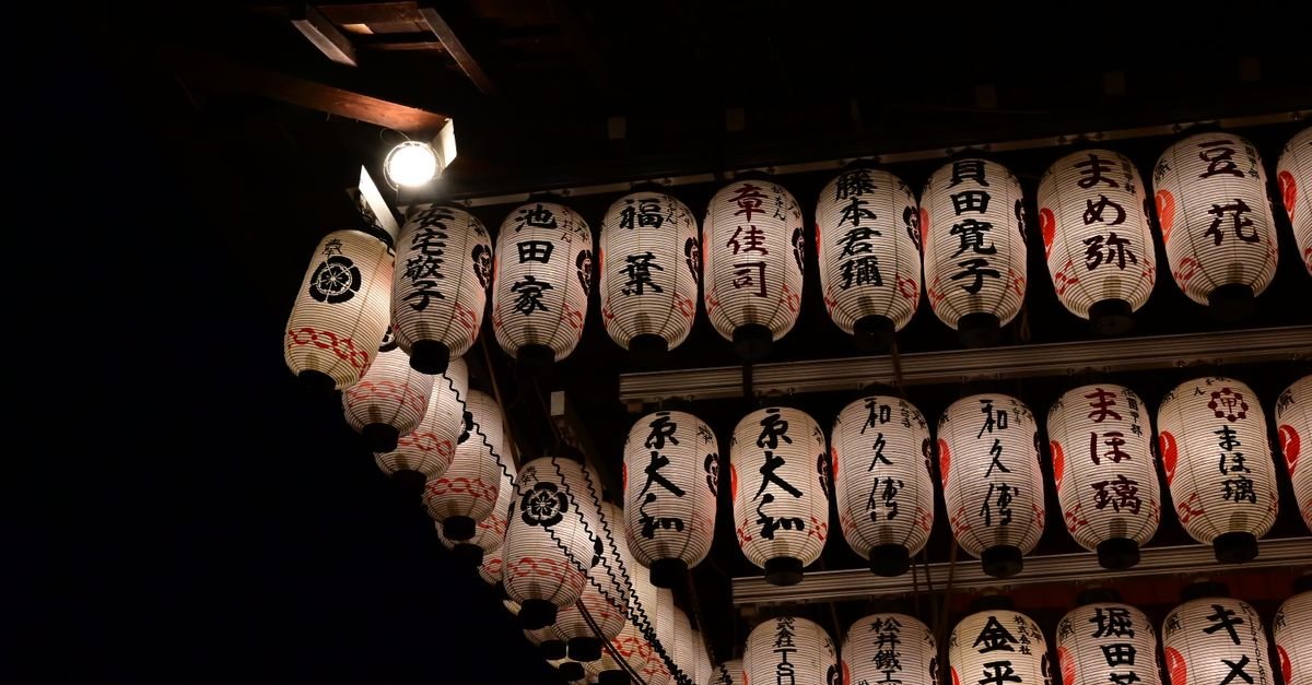 Fileiras de lanternas de papel japonesas iluminadas à noite, em imagem ilustrativa de festival japonês