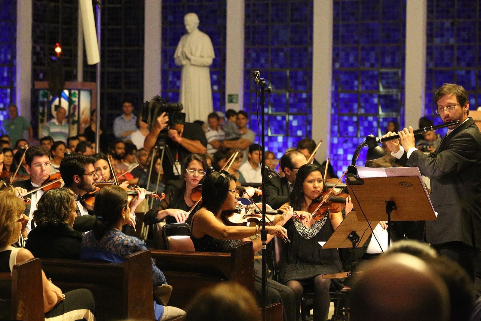 Violinistas e flautista da Orquestra Sinfônica do Teatro Nacional durante concerto, em foto de 2015