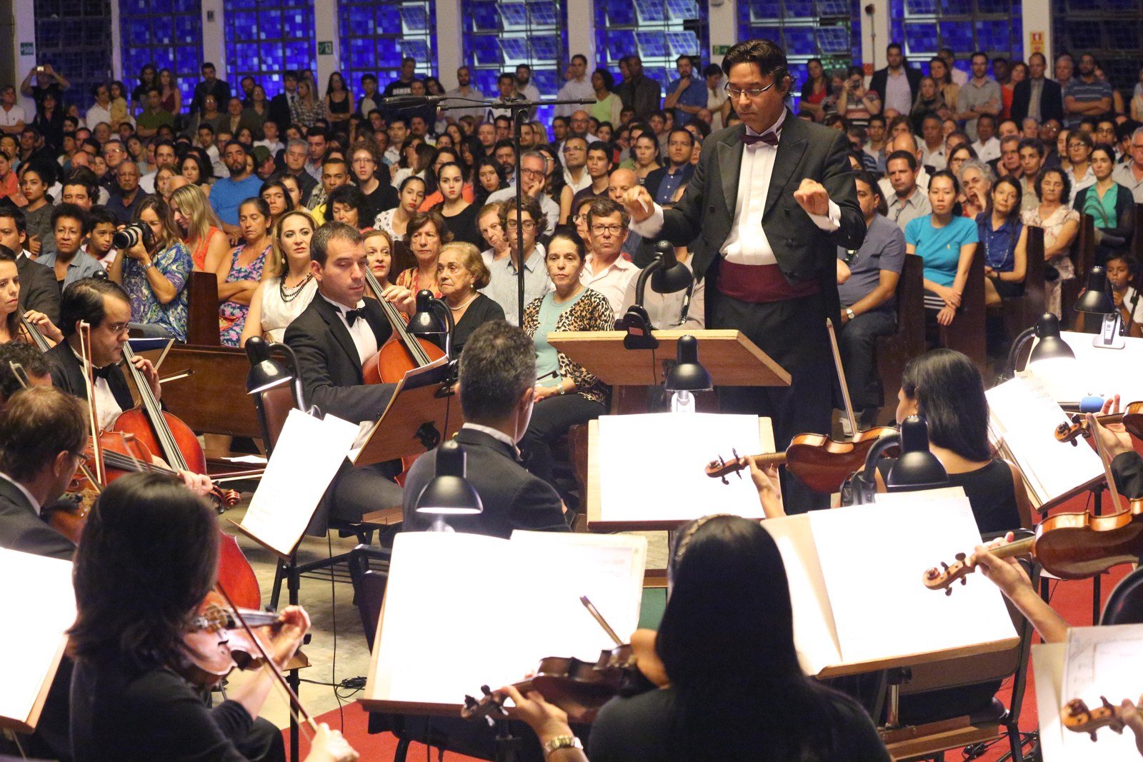 Maestro rege a Orquestra Sinfônica do Teatro Nacional diante de plateia lotada, em apresentação de abertura de temporada em 2015