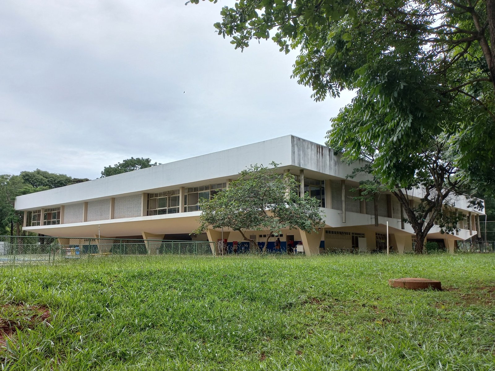 Prédio modernista da Escola Parque da 308 Sul, em Brasília, cercado de árvores e gramado