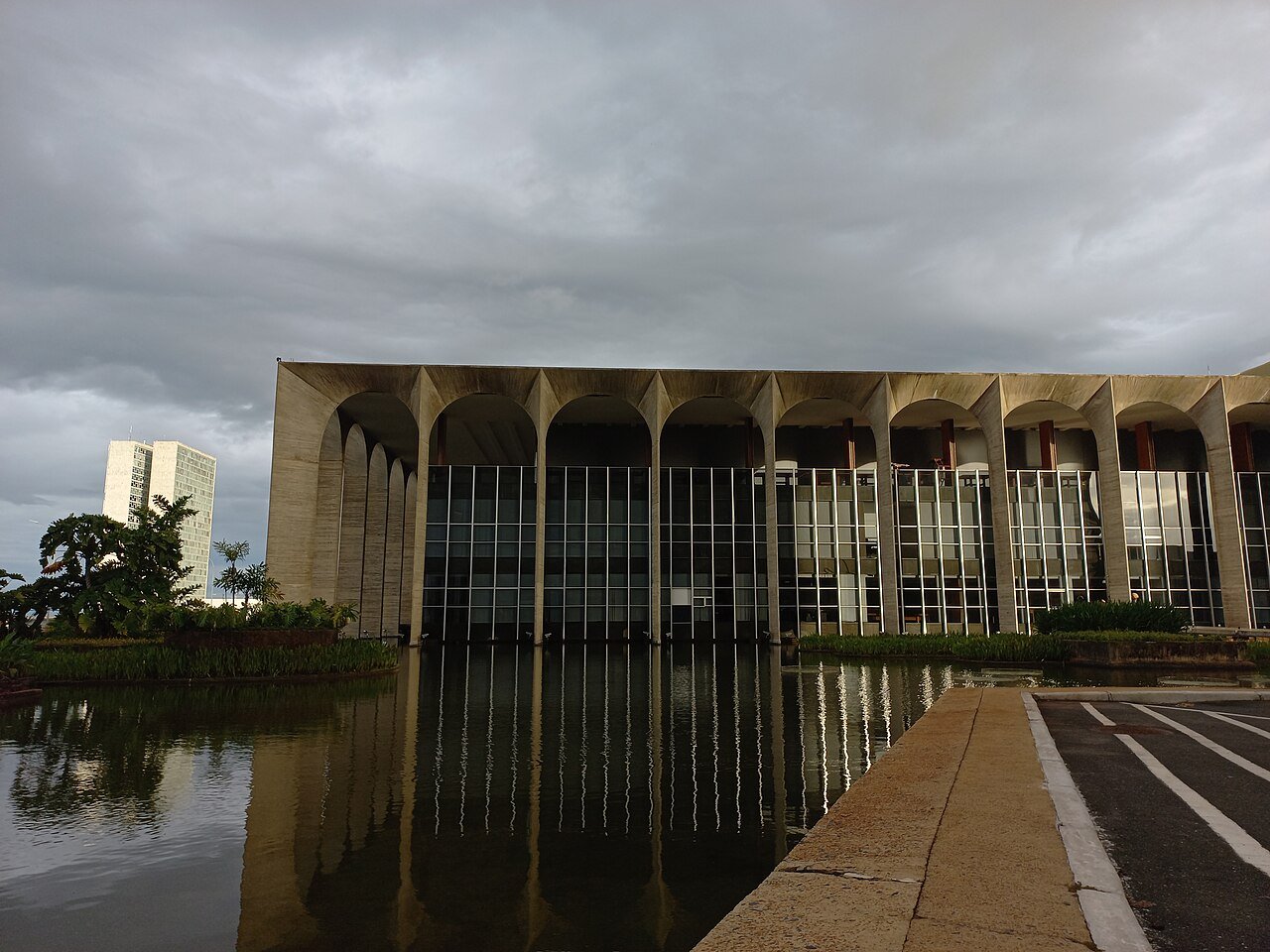 Fachada do Palácio do Itamaraty, em Brasília, com os arcos de concreto refletidos no espelho d'água