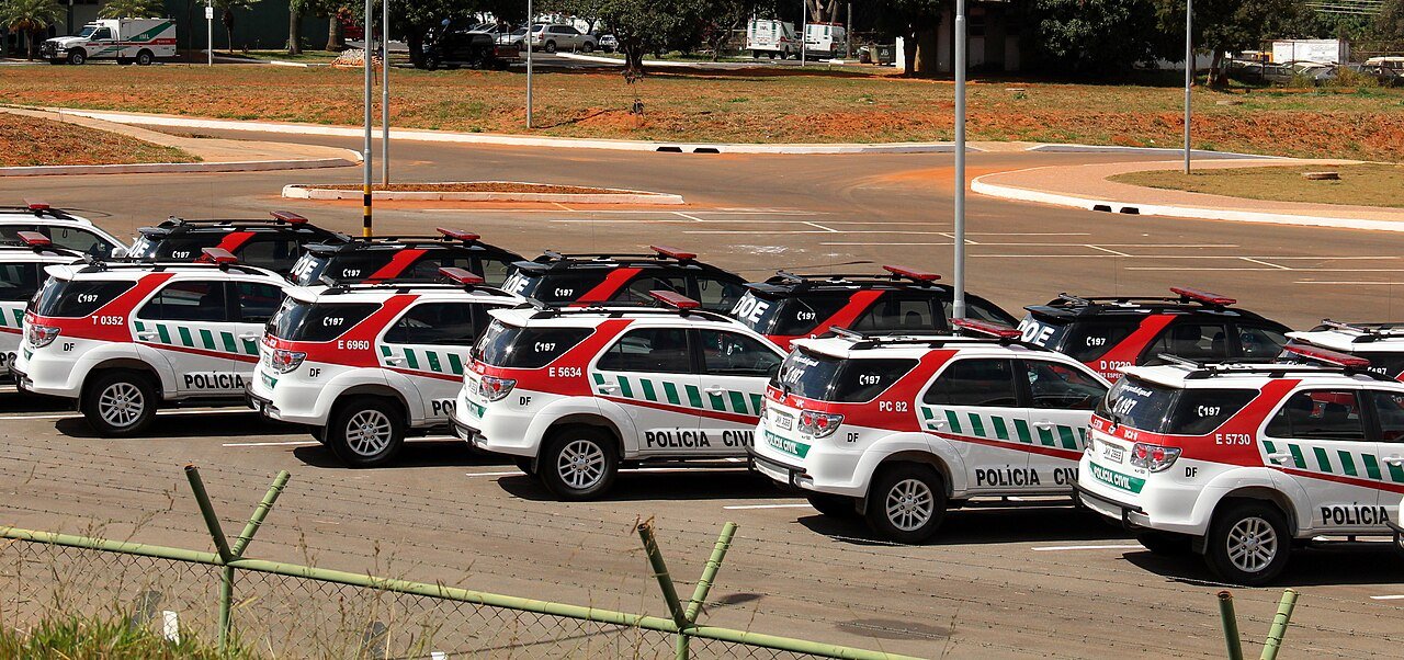 Viaturas da Polícia Civil do Distrito Federal estacionadas em fila em área aberta