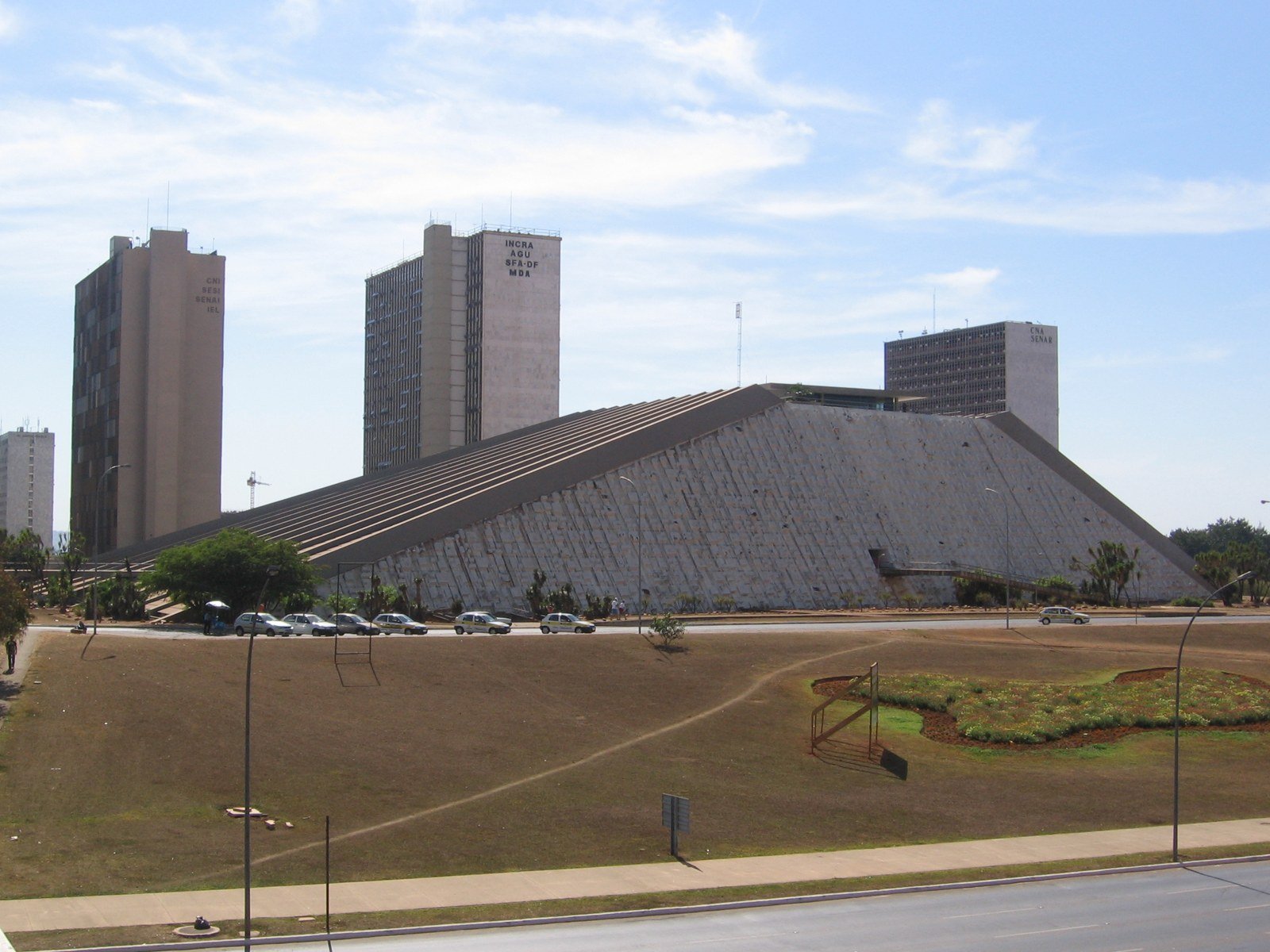 Teatro Nacional Cláudio Santoro, em Brasília, visto da lateral, com torres de órgãos federais ao fundo