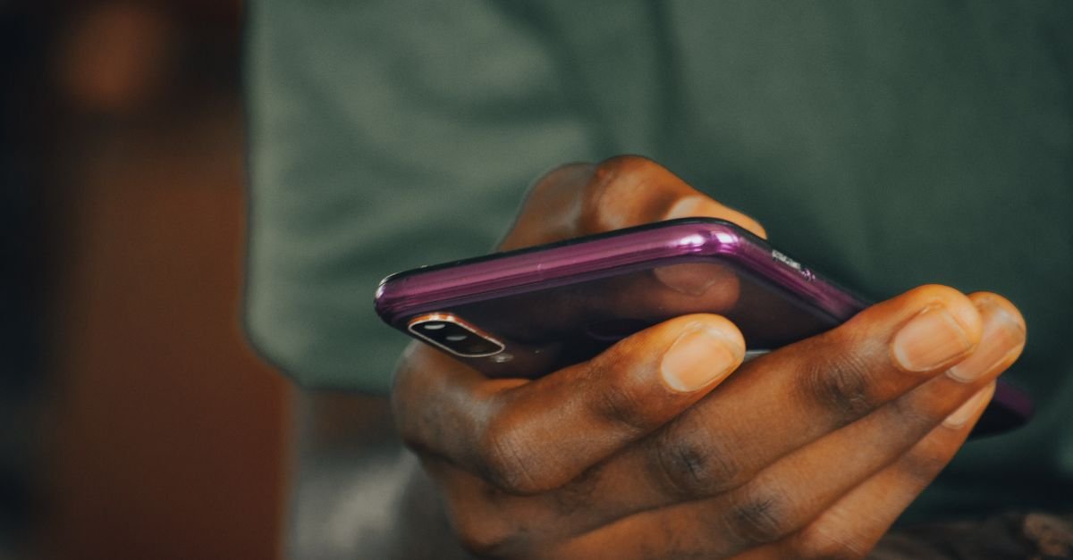 Mãos de pessoa segurando smartphone em close